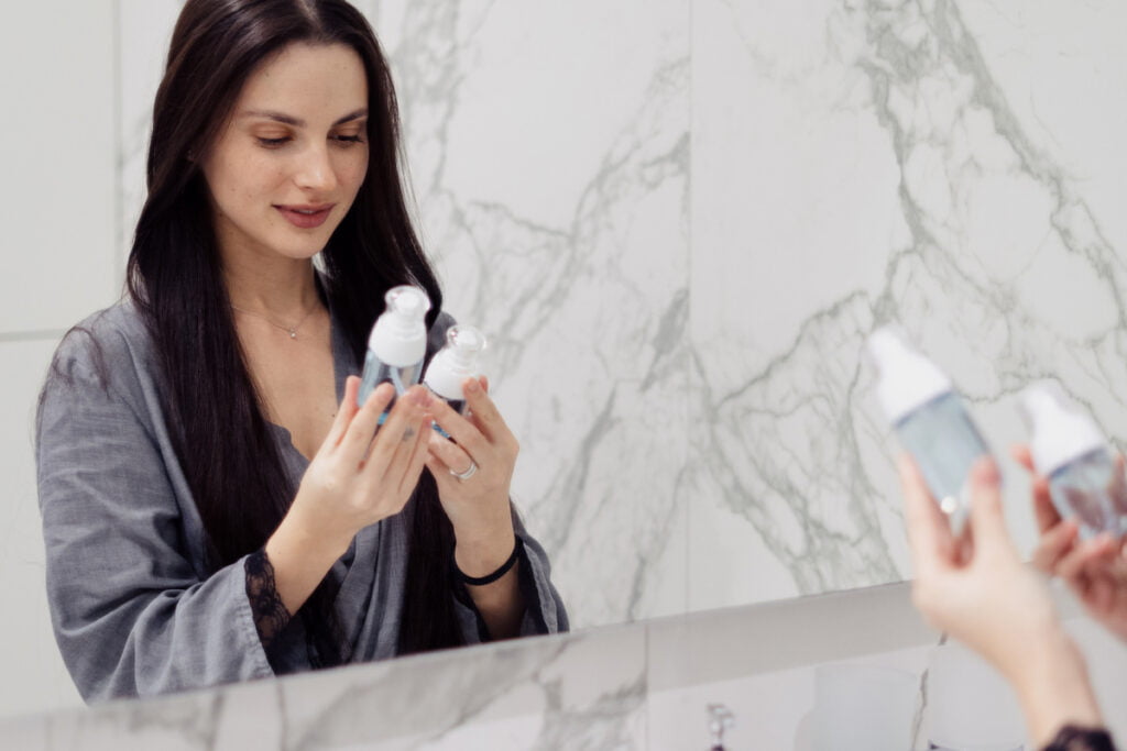 Woman looking at the ingredient list of her skincare products