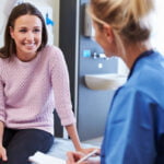 Woman talking to a patient care coordinator before a cosmetic surgery consultation